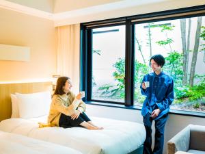 un homme et une femme debout dans une chambre d'hôtel dans l'établissement Hyatt Place Kyoto, à Kyoto
