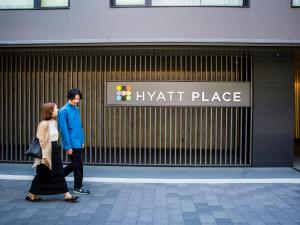 京都的住宿－Hyatt Place Kyoto，男人和女人在一处栖息地前走