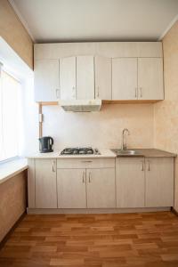 a kitchen with white cabinets and a sink at Дашковича 30, центр міста in Cherkasy