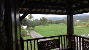 uma vista a partir de uma varanda de uma estrada e campos em Rumah Jepun em Mataram