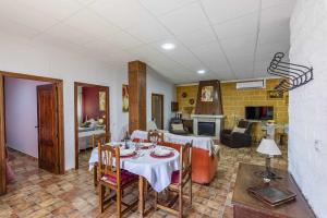 a dining room with a table and a living room at Casa Rural Casita de la Cantera in La Lantejuela