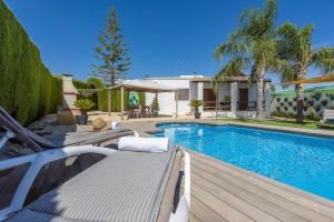 a swimming pool with a bench next to a house at Casa Rural Casita de la Cantera in La Lantejuela