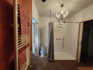 La salle de bains est pourvue d'une douche et d'un lustre. dans l'établissement Casa Etrusca, à Città di Castello