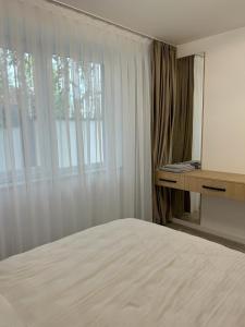 Un dormitorio con una cama grande y una ventana en Traian Taranu Apartment en Suceava