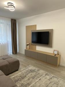 sala de estar con TV de pantalla plana en la pared en Traian Taranu Apartment en Suceava