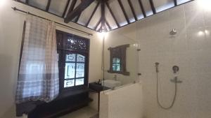uma casa de banho com um chuveiro, um lavatório e uma janela em Rumah Jepun em Mataram