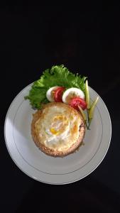 une assiette blanche avec un sandwich aux œufs et une salade dans l'établissement Rumah Jepun, à Mataram