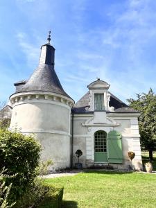 una vecchia casa con una torre sul prato di La Vieille Bouverie a Savennières