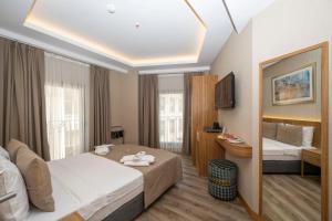 ein Hotelzimmer mit einem Bett und einem TV in der Unterkunft Hotel Ravi in Istanbul