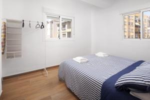 ein weißes Schlafzimmer mit einem Bett und zwei Fenstern in der Unterkunft Apartamento Torre del Mar in Torre del Mar