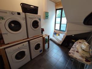une buanderie avec deux lave-linge et une fenêtre dans l'établissement 4 studios - Musique en Champagne, à Châlons-en-Champagne