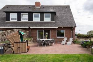 una casa con patio arredato con tavolo e sedie di Dacklünen a Wenningstedt