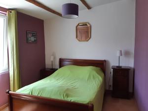 a bedroom with a green bed and a window at La Caleche in Bégadan