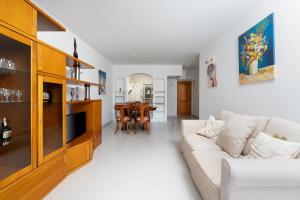 Una sala de estar con un sofá blanco y una mesa. en Vila Gaivota 1C, en Ferragudo