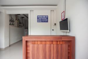 a wooden podium with a television on top of it at RedDoorz @ Kali Balok Lampung in Geruntang