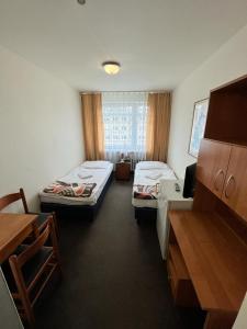 a room with two beds and a desk in it at Jantar Resort in Szczecin