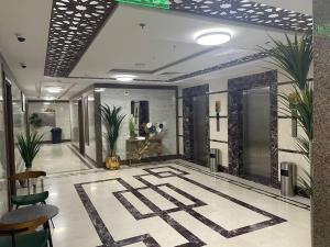 eine Lobby eines Gebäudes mit Pflanzen auf dem Boden in der Unterkunft ديار المشاعر للشقق المخدومة Diyar Al Mashaer For Serviced Apartments in Mekka