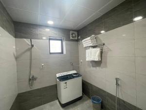 a bathroom with a shower and a trash can at ديار المشاعر للشقق المخدومة Diyar Al Mashaer For Serviced Apartments in Mecca