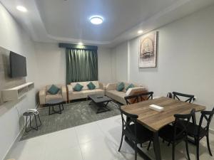 un soggiorno con tavolo e divano di ديار المشاعر للشقق المخدومة Diyar Al Mashaer For Serviced Apartments a La Mecca