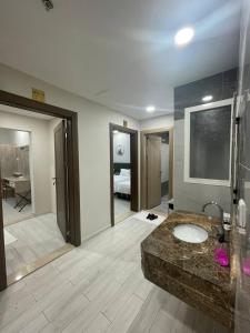 a bathroom with a sink and a room with a bedroom at ديار المشاعر للشقق المخدومة Diyar Al Mashaer For Serviced Apartments in Makkah