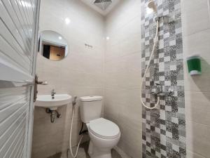 a bathroom with a toilet and a sink at Check Inn at Citarum in Semarang