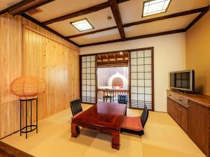 - un salon avec une table et une télévision dans l'établissement AsoTsuruya, à Aso