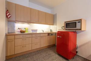 a kitchen with a red refrigerator and a microwave at ST33-22 - Appartement Typ D in Dorum Neufeld