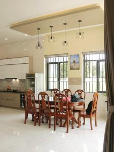 cocina y comedor con mesa y sillas en Villa 26-28 Châu Đốc, en Chau Doc