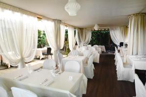 a restaurant with white tables and white chairs at Al Borgo in Lucca