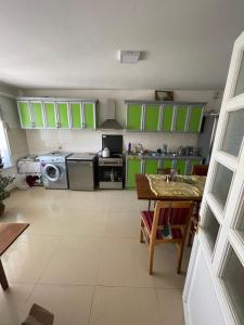 una cocina con armarios verdes y una mesa. en Zoratc QARER, en Sisian
