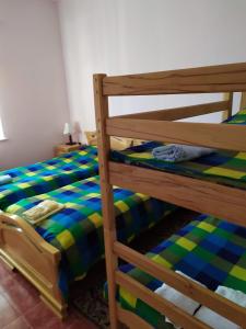 łóżko piętrowe z zieloną i niebieską pościelą w obiekcie Zoratc QARER w mieście Sisian