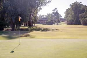 Corowa Golf Club Motel في كوروا: ملعب قولف مع العلم على الاخضر