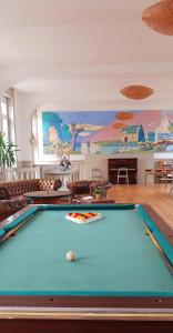 a pool table in a living room with a painting at Le Château de Sable in Plougasnou