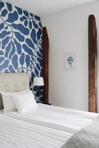 a bedroom with a bed with a blue and white wall at Kalk Hotel in Visby