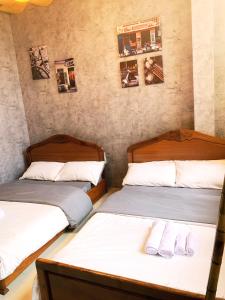 2 łóżka pojedyncze w pokoju z 2 łóżkami w obiekcie Nhà Quê Homestay w mieście Nha Trang