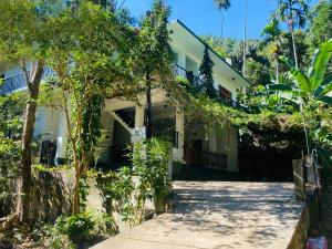 a white building with trees in front of it at Misty Elegance - Ella. in Ella