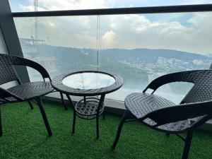 2 sillas y mesa en un balcón con vistas en Empire City Hotel Petaling Jaya en Petaling Jaya