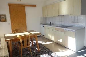 eine Küche mit einem Holztisch und Stühlen in der Unterkunft Ferienwohnung Stoll Helga in Burgberg