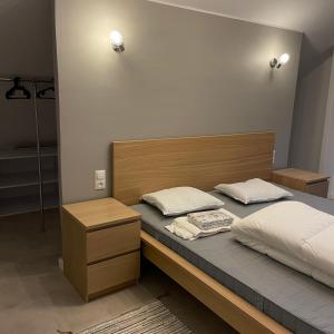 Schlafzimmer mit einem Bett mit einem Kopfteil aus Holz in der Unterkunft Przestronny Apartament in Sagan