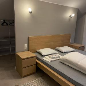 a bedroom with a bed with a wooden headboard at Przestronny Apartament in Żagań