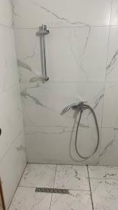 y baño de azulejos blancos con ducha. en Borsh Beach Apartments - BBA, en Borsh