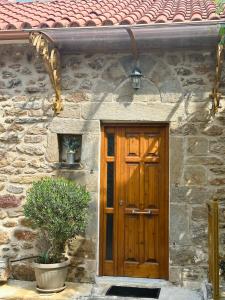 una casa de piedra con una puerta de madera y una planta en Anastasia’s Home, 
