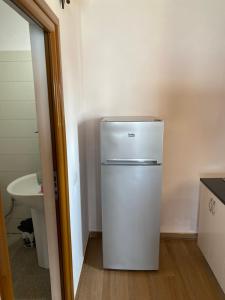 um frigorífico branco numa cozinha com um lavatório em Borsh Beach Apartments - BBA em Borsh