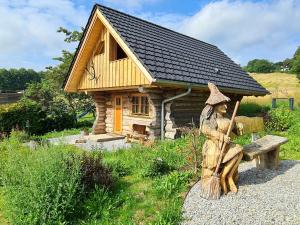 a statue of a person sitting on a bench in front of a house at Blockhaus PanHütte in Braunlage