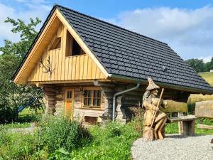 una pequeña cabaña de madera con una estatua delante de ella en Blockhaus PanHütte, en Braunlage
