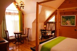 GuestHaven Home Baguio في باغيو: غرفة نوم بسرير ومكتب وطاولة
