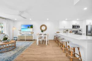 een witte keuken met een aanrecht en krukken bij Lux Beachside 2nd Floor Condo. Steps to the Beach! in Juno Beach