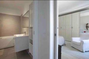 a white bathroom with a bed and a bath tub at Amadeus Apartment: a due passi dal Duomo in Treviso