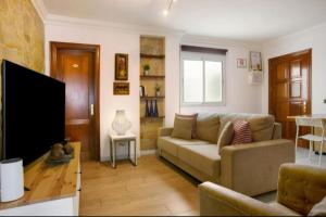 un soggiorno con divano e TV a schermo piatto di Magara suites Las Canteras a Guanarteme