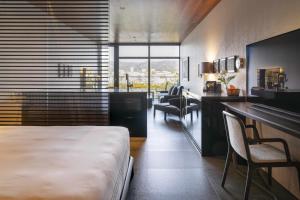 a hotel room with a bed and a desk and chairs at Kamo Residences by Reflections in Kyoto +76 photos